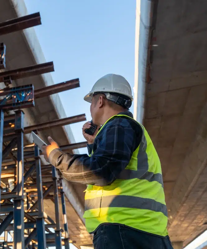 Homme en gilet de sécurité et casque sur chantier